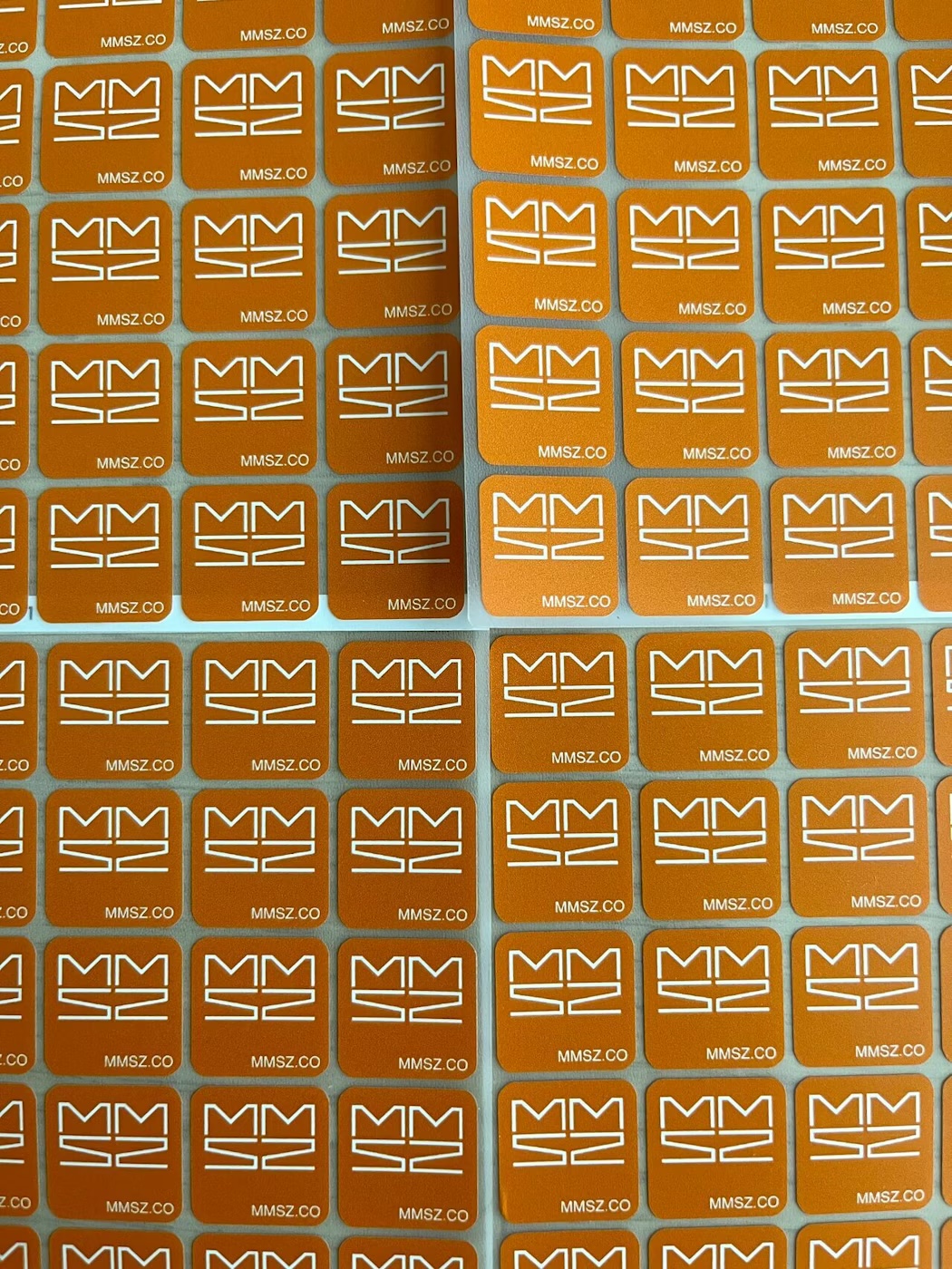 Sheets of orange MMSZ.CO branded patch labels